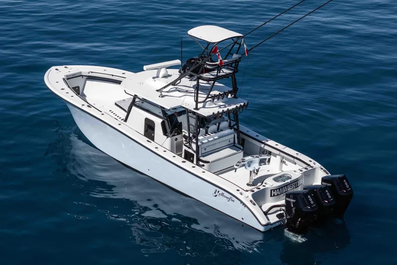  Yacht Photos Pics 2025 Yellowfin 42 Offshore boat on calm blue water, featuring triple outboard engines.