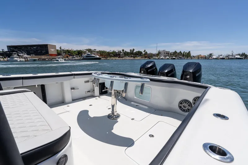  Yacht Photos Pics 2025 Yellowfin 42 Offshore boat with triple Mercury engines, docked in a scenic marina.
