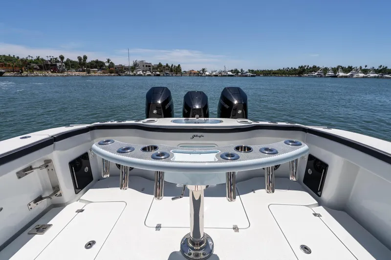  Yacht Photos Pics 2025 Yellowfin 42 Offshore boat with triple engines, docked in a scenic marina.