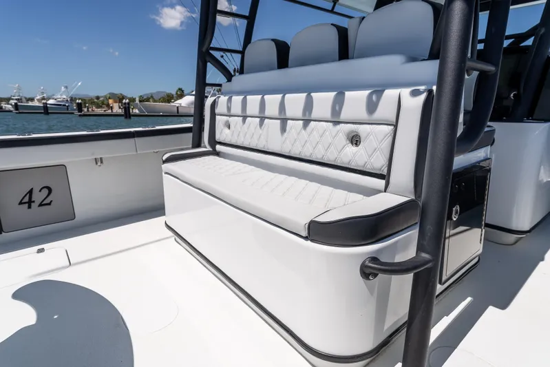  Yacht Photos Pics 2025 Yellowfin 42 Offshore boat interior with cushioned seating and sleek design.