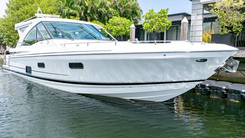  Yacht Photos Pics 2021 Formula 430 Super Sport Crossover boat docked in a serene waterfront setting.