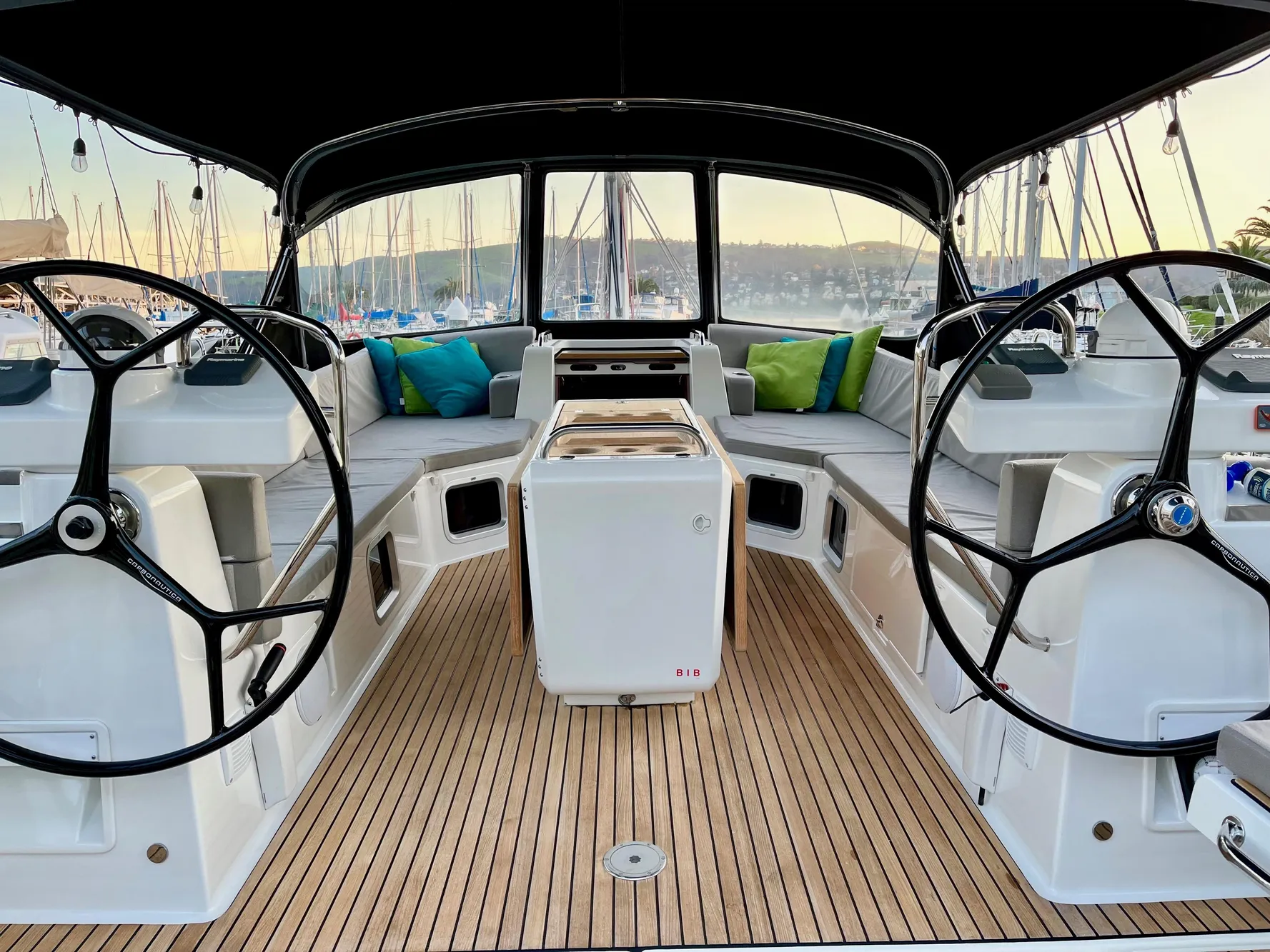 Luxurious 2016 Jeanneau 54 yacht cockpit with dual steering wheels and elegant seating.