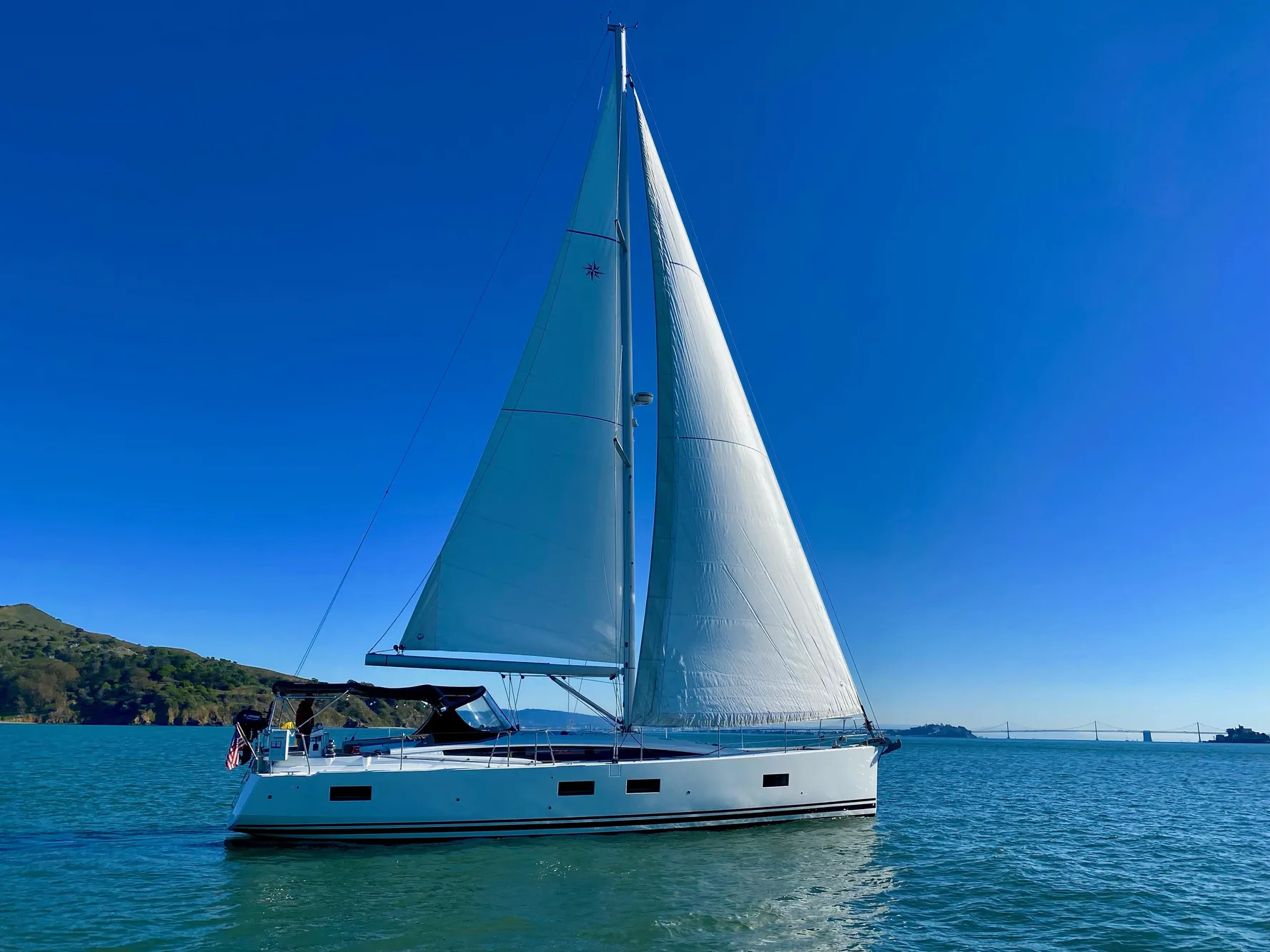 2016 Jeanneau 54 sailboat cruising on calm waters under clear blue skies.