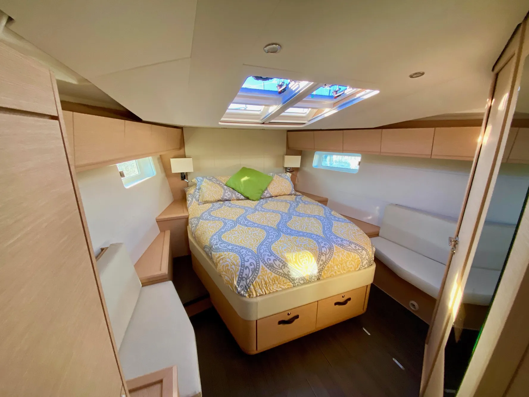 Luxurious cabin interior of 2016 Jeanneau 54 yacht with skylights and cozy bed.