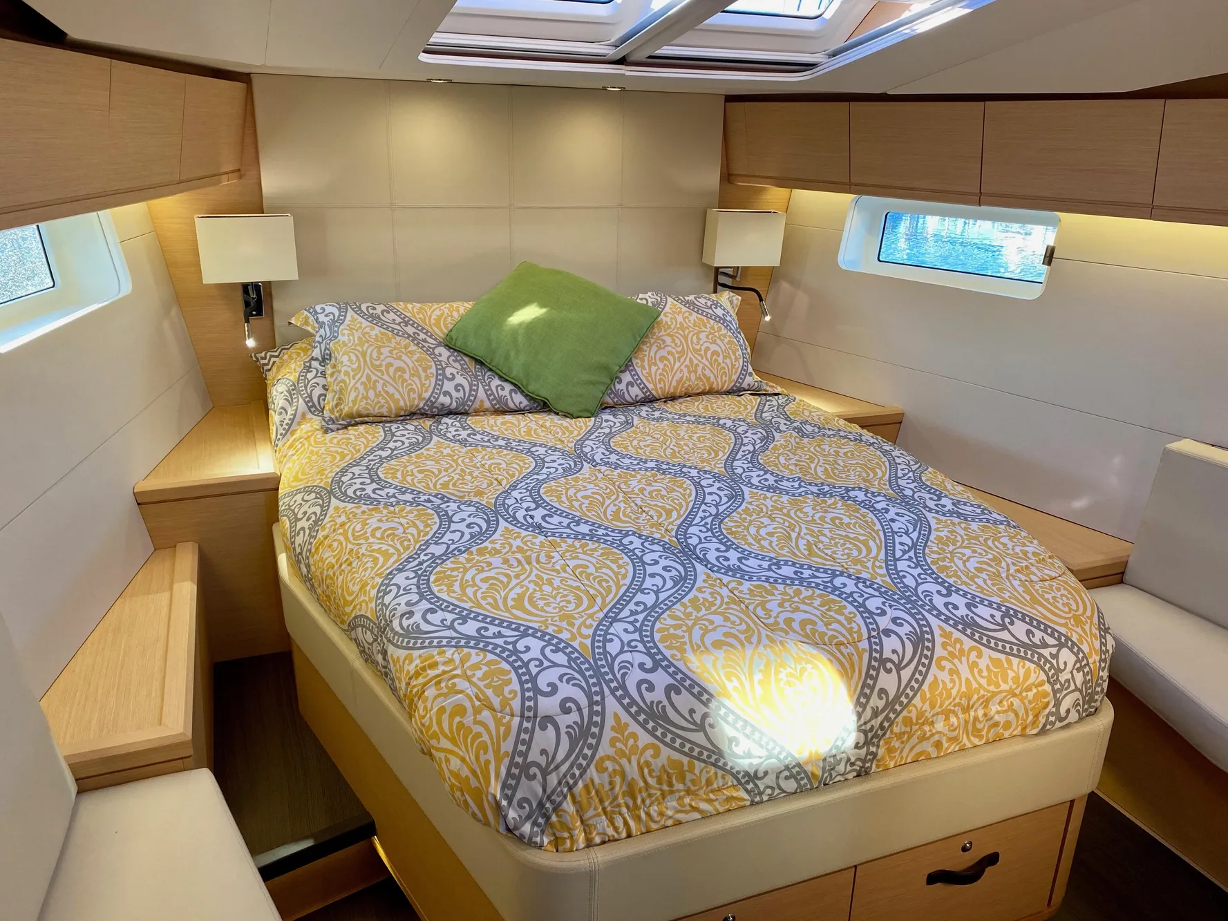 Luxurious cabin interior of a 2016 Jeanneau 54 yacht with elegant bedding and natural light.