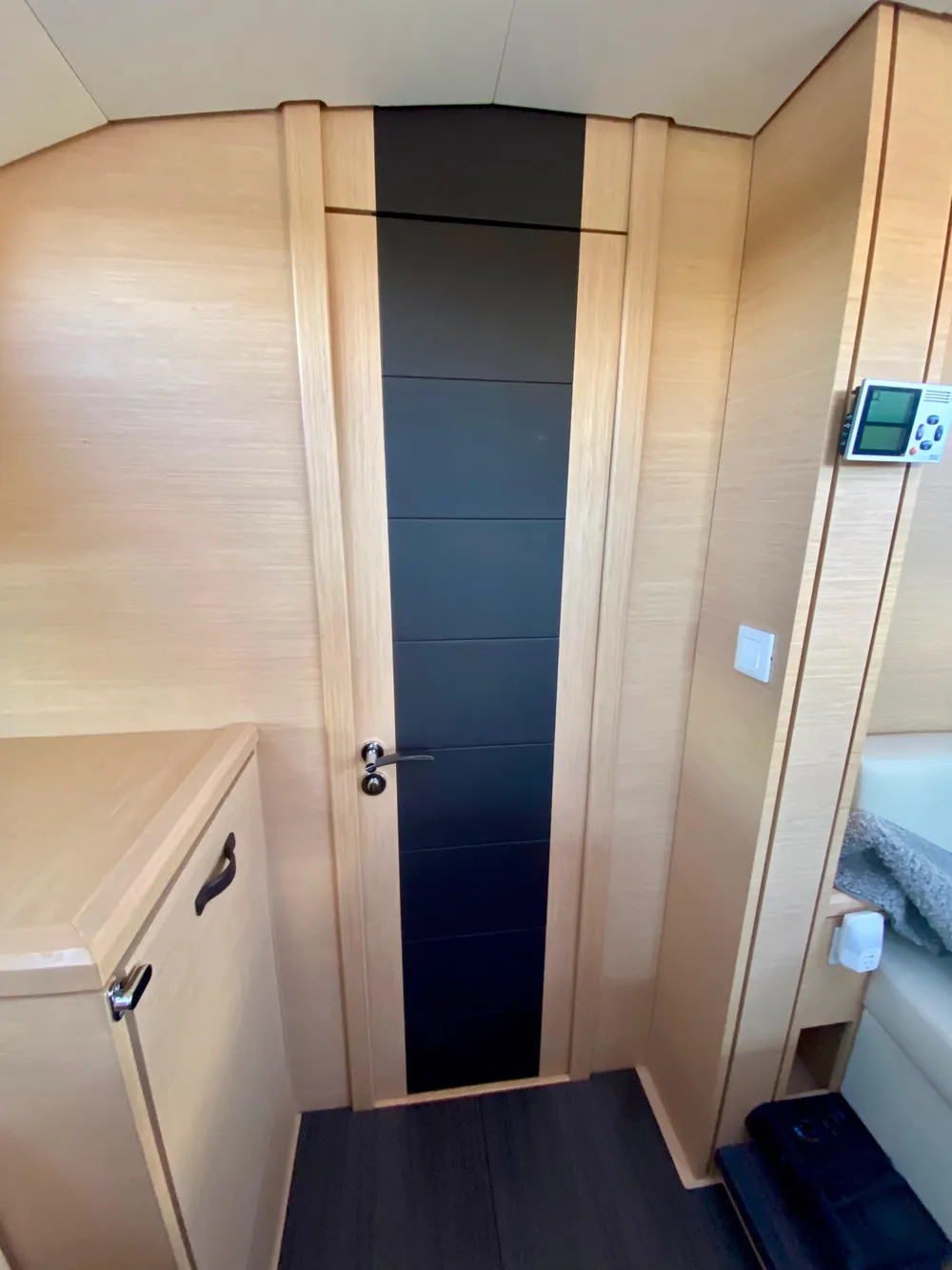 Interior of 2016 Jeanneau 54 yacht with modern wood finish and sleek door design.