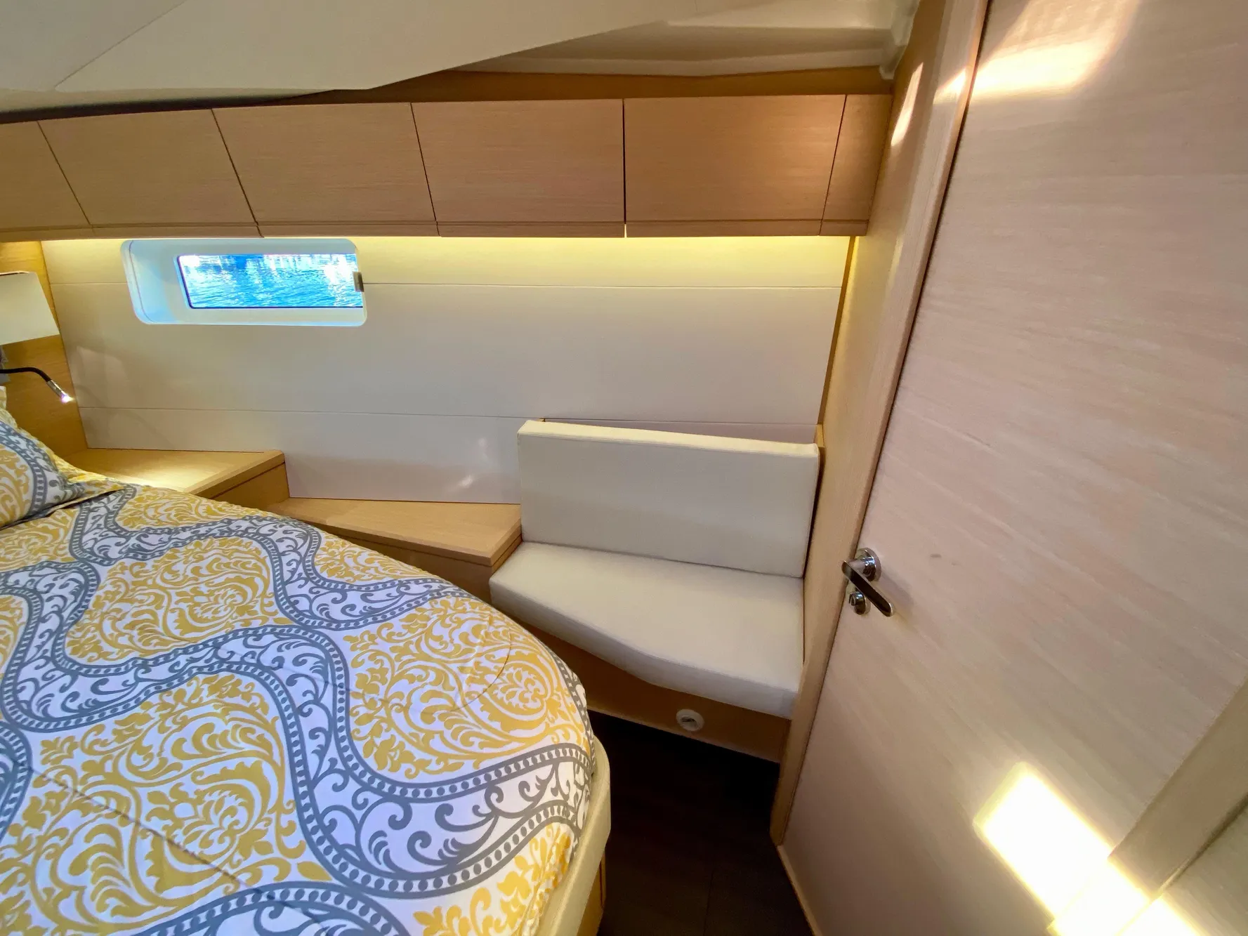 Luxurious cabin interior of 2016 Jeanneau 54 yacht with elegant bedding and seating.
