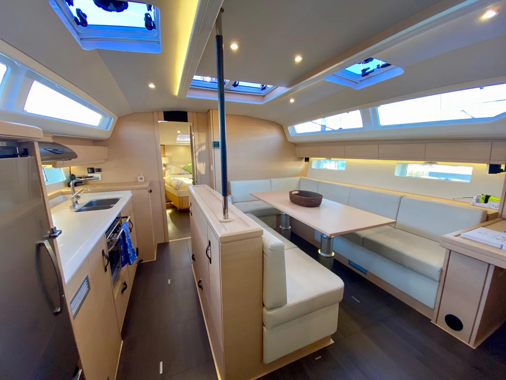 Luxurious interior of 2016 Jeanneau 54 yacht with modern kitchen and spacious seating area.