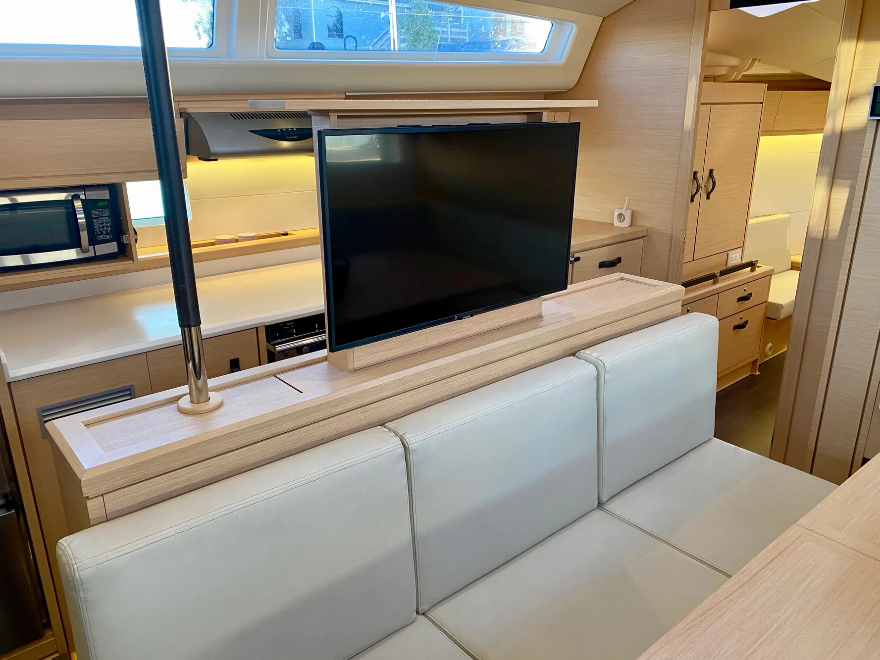 Interior of 2016 Jeanneau 54 yacht with modern kitchen and retractable TV.