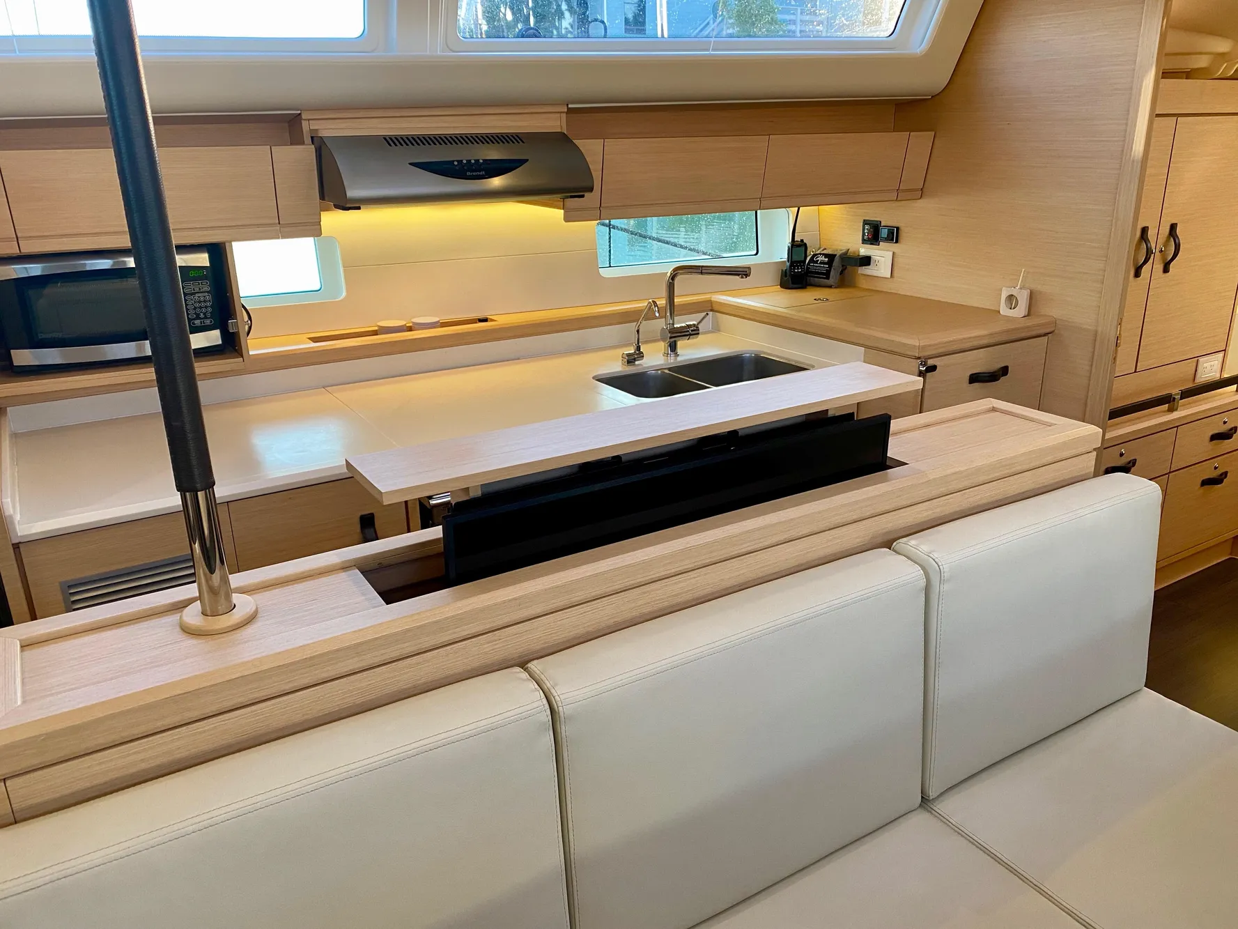 Modern kitchen interior of 2016 Jeanneau 54 yacht with sleek cabinetry and appliances.