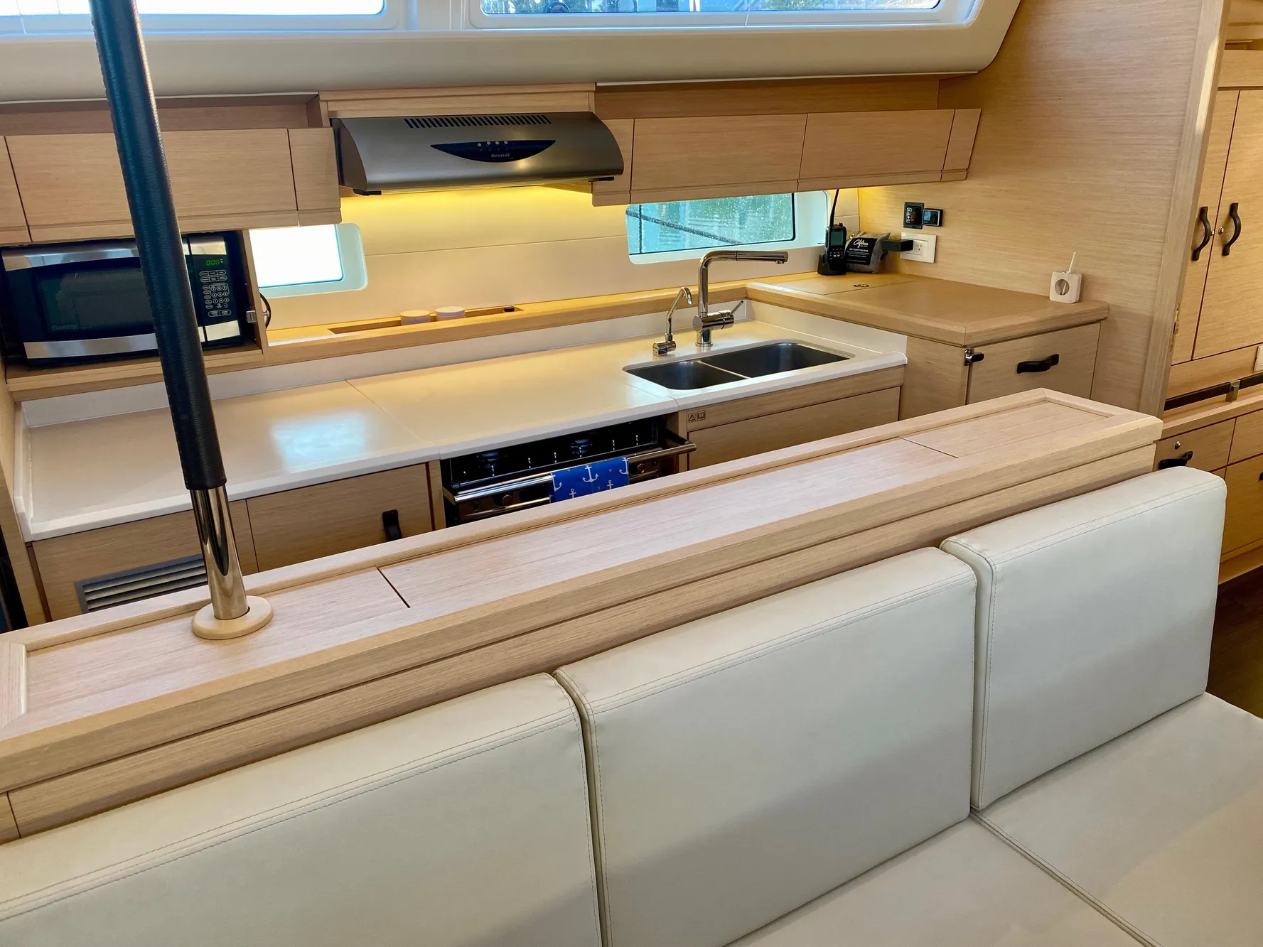 Modern kitchen interior of 2016 Jeanneau 54 yacht with sleek cabinetry and appliances.