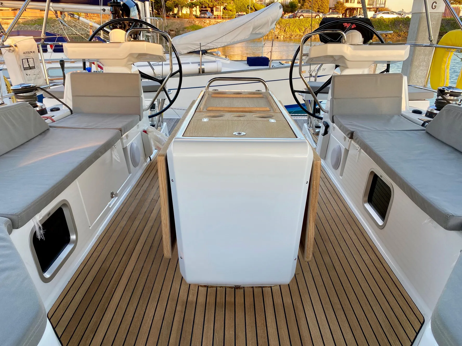 Jeanneau 54 sailboat cockpit, 2016 model, featuring dual steering wheels and teak flooring.