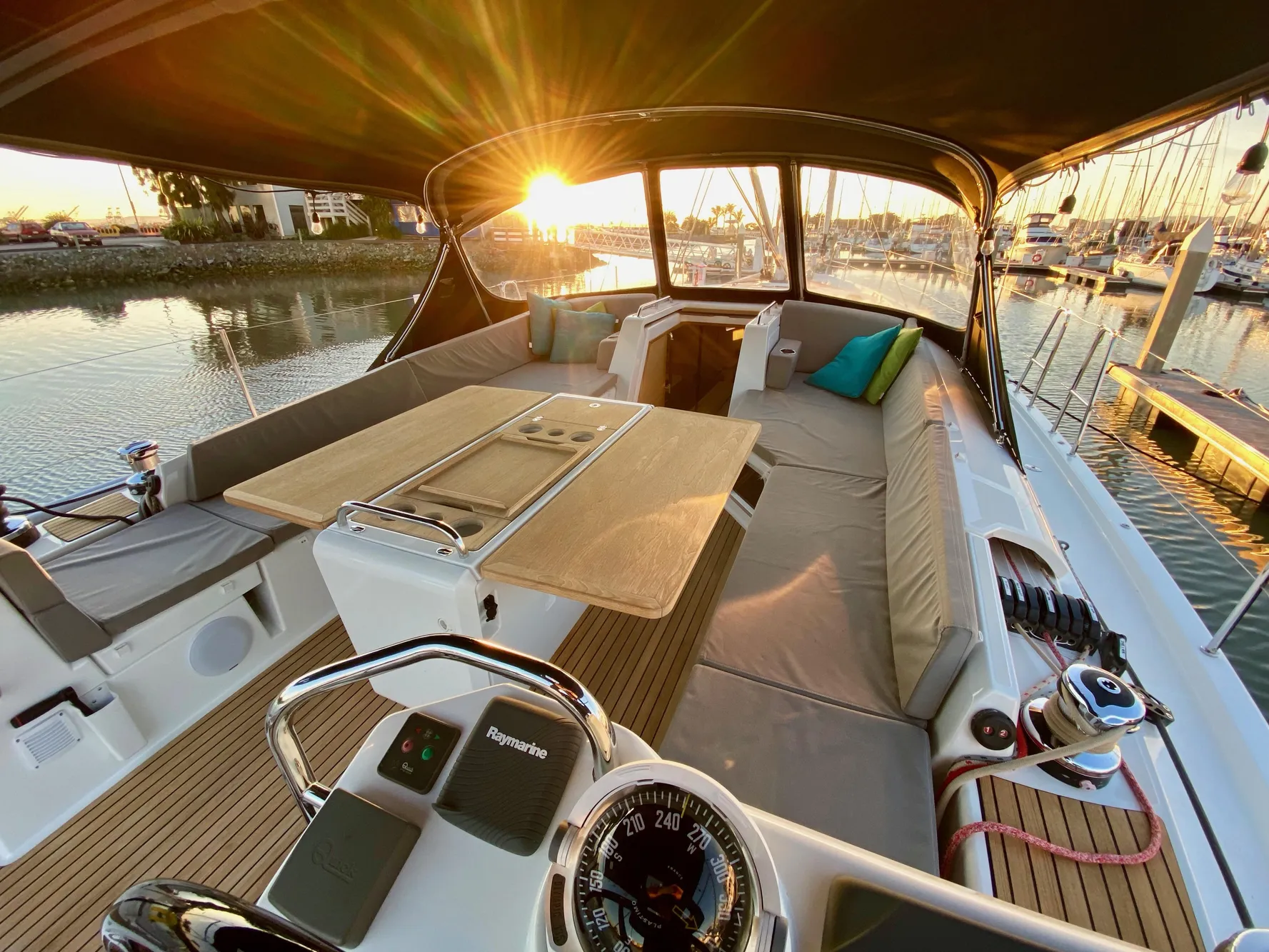 Luxurious 2016 Jeanneau 54 yacht interior with sunset view, featuring spacious seating and elegant design.