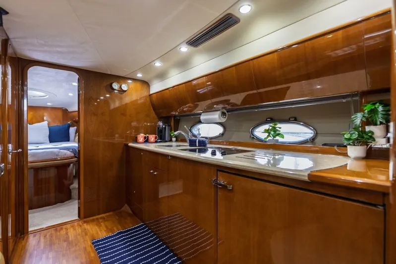 Blue Tang Gang Yacht Photos Pics Luxurious 2005 Viking Princess 58V yacht interior with modern kitchen and cozy bedroom.