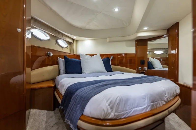 Blue Tang Gang Yacht Photos Pics Luxurious cabin interior of 2005 Viking Princess 58V yacht with cozy bed and elegant decor.
