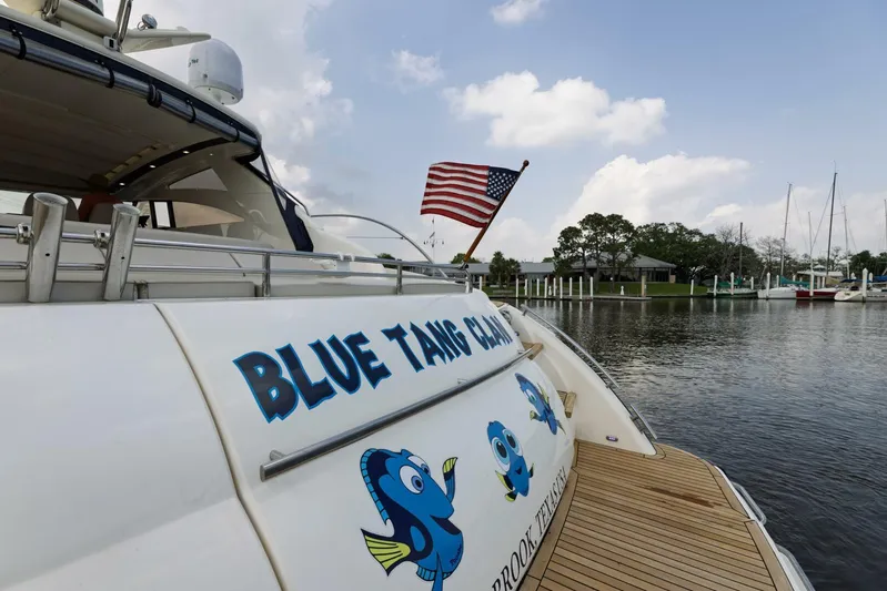 Blue Tang Gang Yacht Photos Pics Viking Princess 58V yacht, 2005 model, named "Blue Tang Clan" with American flag, docked by water.