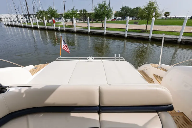 Blue Tang Gang Yacht Photos Pics 2005 Viking Princess 58V yacht stern view with American flag, docked by a marina.