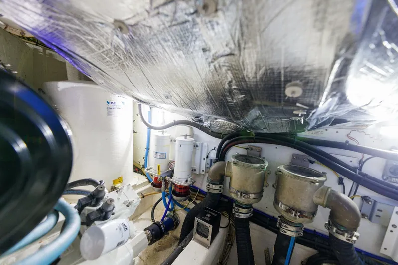 Blue Tang Gang Yacht Photos Pics Engine room of 2005 Viking Princess 58V yacht with visible pipes and machinery.