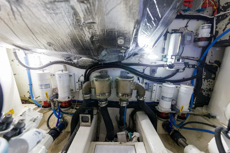 Blue Tang Gang Yacht Photos Pics Engine room of 2005 Viking Princess 58V yacht, showcasing complex machinery and piping.