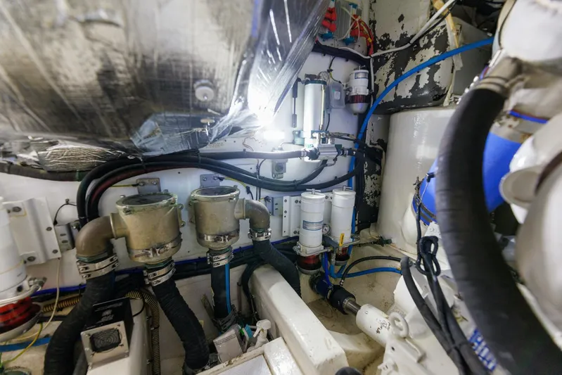 Blue Tang Gang Yacht Photos Pics Engine room of a 2005 Viking Princess 58V yacht, showcasing mechanical components and piping.