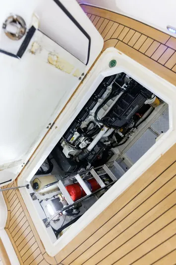 Blue Tang Gang Yacht Photos Pics Engine compartment of 2005 Viking Princess 58V yacht with visible machinery and wooden deck.