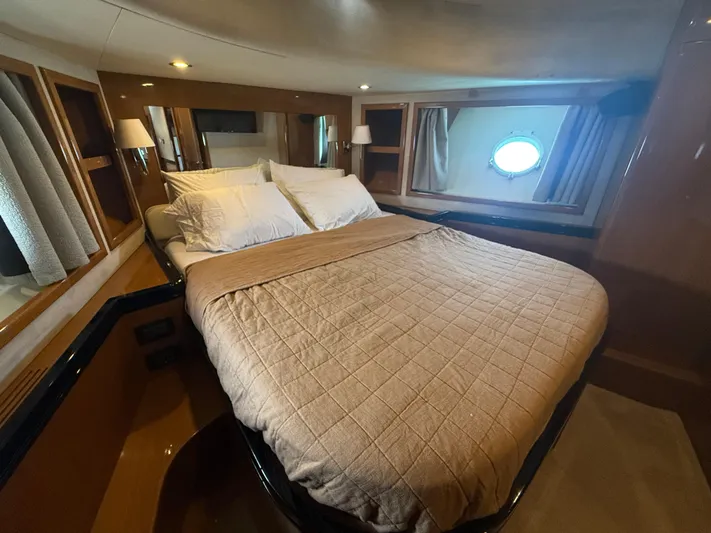  Yacht Photos Pics Luxurious bedroom interior of 2011 Apreamare 65 Maestro yacht with elegant bedding and porthole window.