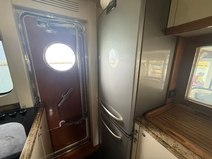  Yacht Photos Pics Interior of 2011 Apreamare 65 MAESTRO yacht kitchen with porthole door and stainless steel fridge.