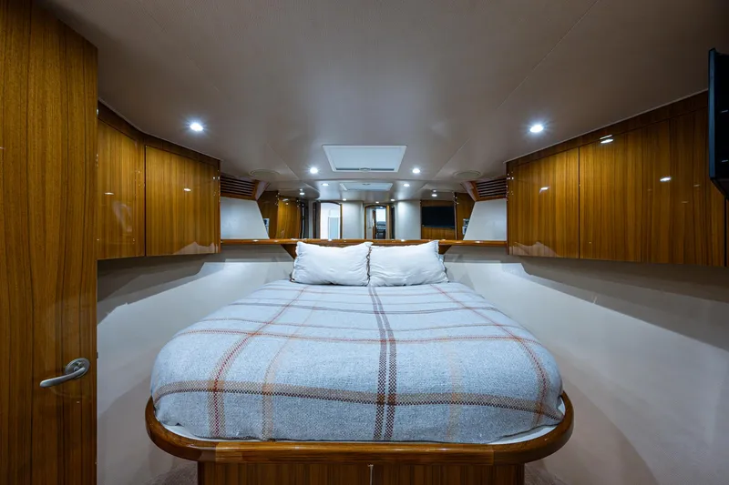 Carolina Style Yacht Photos Pics Luxurious cabin interior of 2012 Viking 60 Enclosed Bridge yacht with cozy bed and wooden cabinetry.