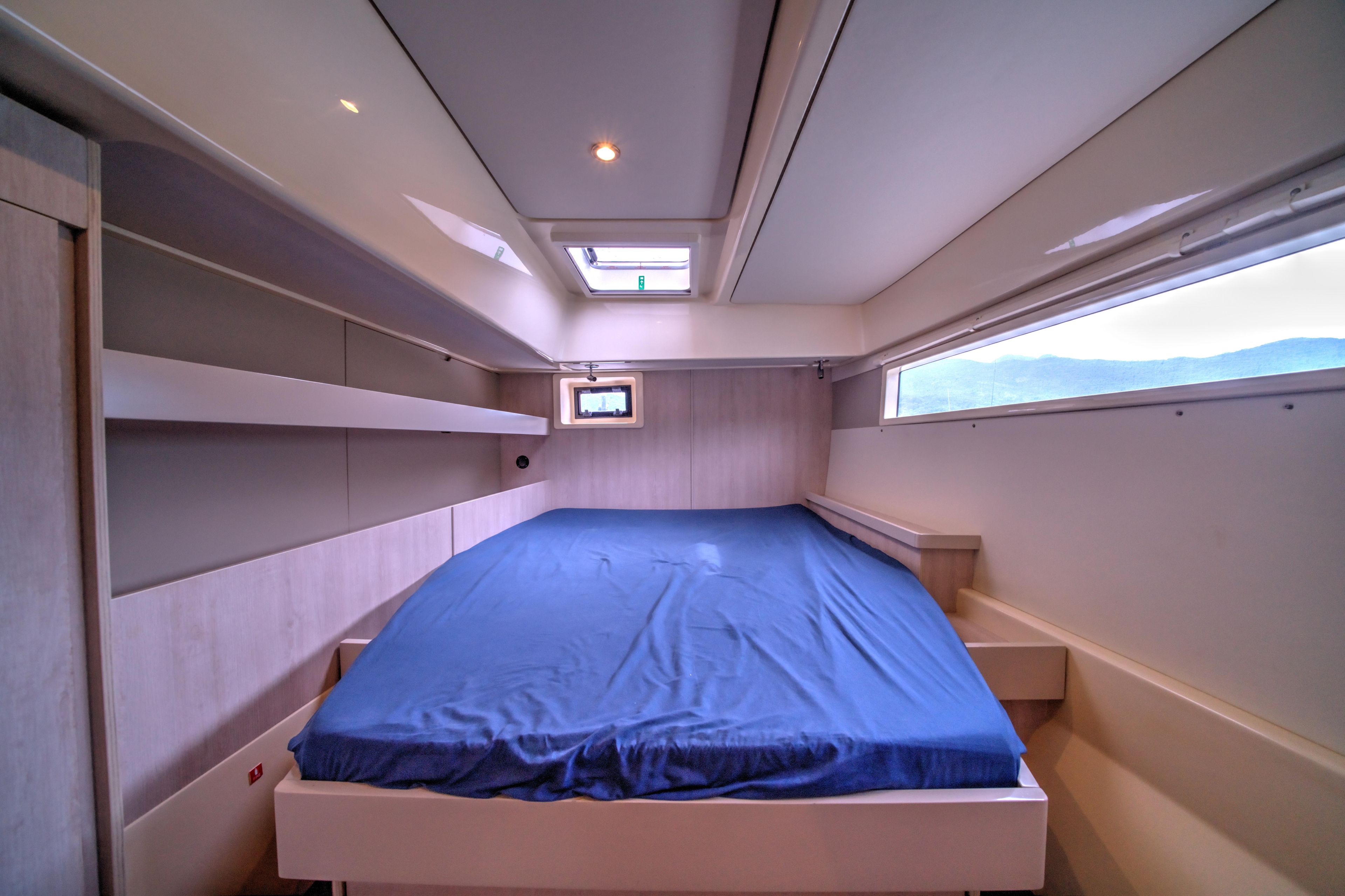 Cabin interior of 2015 Leopard 48 yacht with blue bedding and modern design.