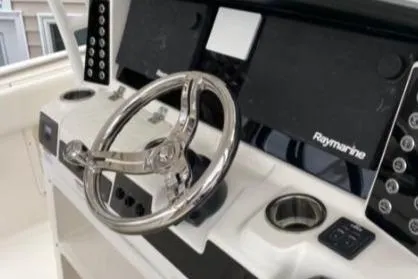 Yacht Photos Pics 2022 Robalo R302 Center Console boat helm with Raymarine electronics and stainless steel steering wheel.