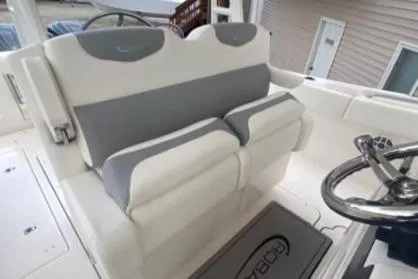  Yacht Photos Pics 2022 Robalo R302 Center Console boat interior with cushioned seating and steering wheel.