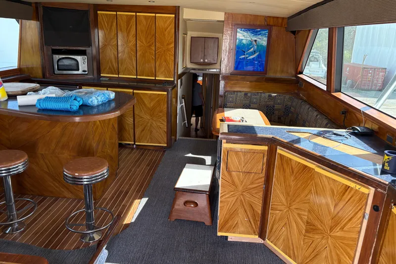 Yacht Photos Pics Interior of a 1994 Bertram 60 Convertible yacht with wood paneling and bar stools.