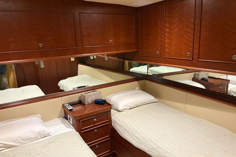  Yacht Photos Pics Luxurious cabin interior of 1994 Bertram 60 Convertible yacht with twin beds and wooden cabinetry.