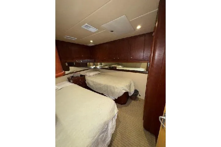  Yacht Photos Pics Interior cabin of 1994 Bertram 60 Convertible yacht with twin beds and wooden cabinetry.