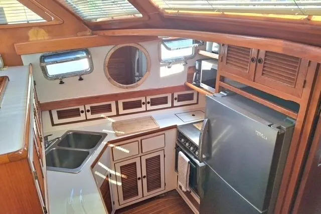 Southern Flite Yacht Photos Pics 1990 Offshore Yachts Trawler kitchen with wooden cabinetry, stainless steel sink, and modern appliances.