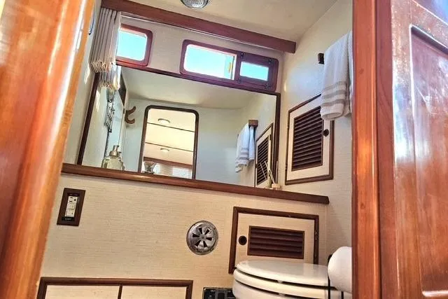 Southern Flite Yacht Photos Pics 1990 Offshore Yachts Trawler bathroom with wooden accents and nautical decor.