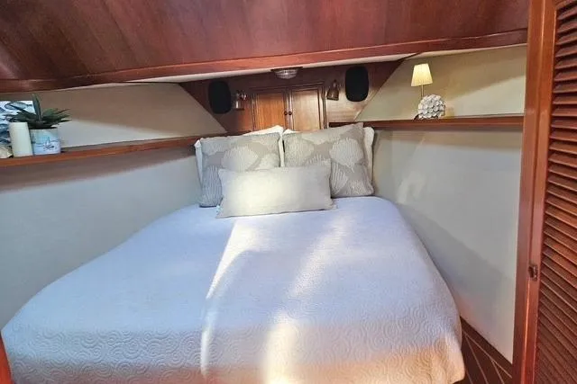 Southern Flite Yacht Photos Pics Cozy bedroom in 1990 Offshore Yachts Trawler with elegant wood paneling and soft lighting.