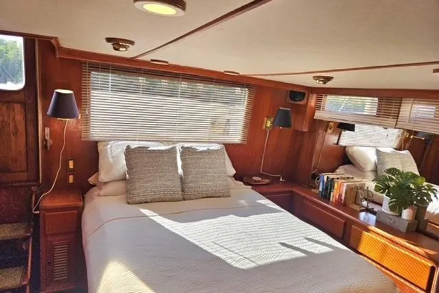 Southern Flite Yacht Photos Pics Cozy bedroom interior of 1990 Offshore Yachts Trawler with wooden accents and natural light.