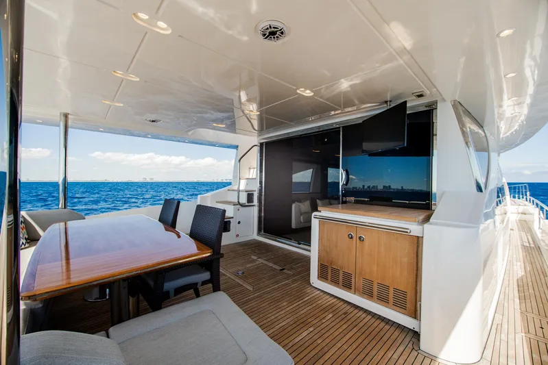 April Fools Yacht Photos Pics 2018 Azimut 80 Flybridge yacht deck with dining area and ocean view.