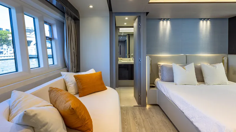 April Fools Yacht Photos Pics Luxurious bedroom interior of 2018 Azimut 80 Flybridge yacht with modern decor and large windows.