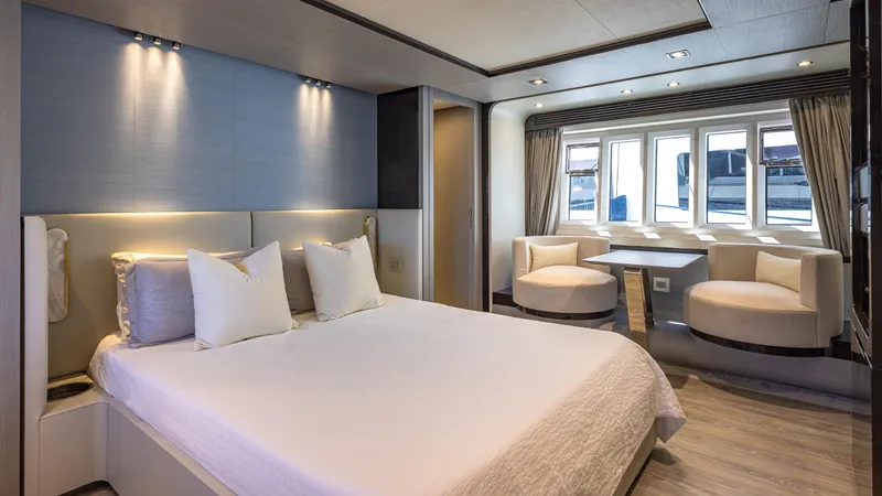 April Fools Yacht Photos Pics Luxurious bedroom interior of 2018 Azimut 80 Flybridge yacht with modern decor and large windows.