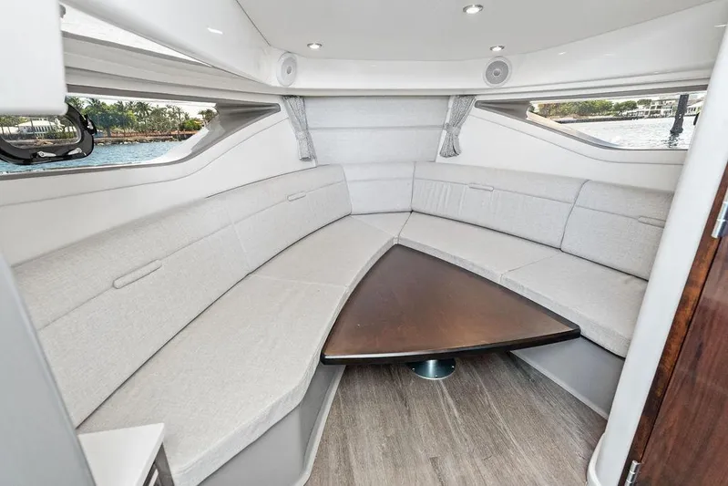 Maxsea Yacht Photos Pics 2022 Sea Ray Sundancer 320 Outboard cabin interior with plush seating and triangular table.