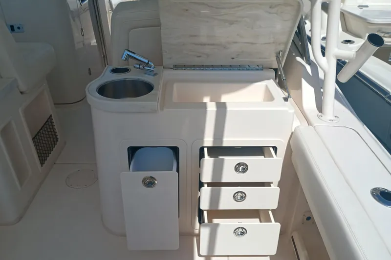 307-310 Yacht Photos Pics 2025 Grady-White Freedom 307 boat interior with sink, storage drawers, and seating.