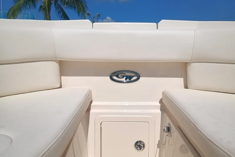 307-310 Yacht Photos Pics 2025 Grady-White Freedom 307 boat interior with logo, white seating, and blue sky background.