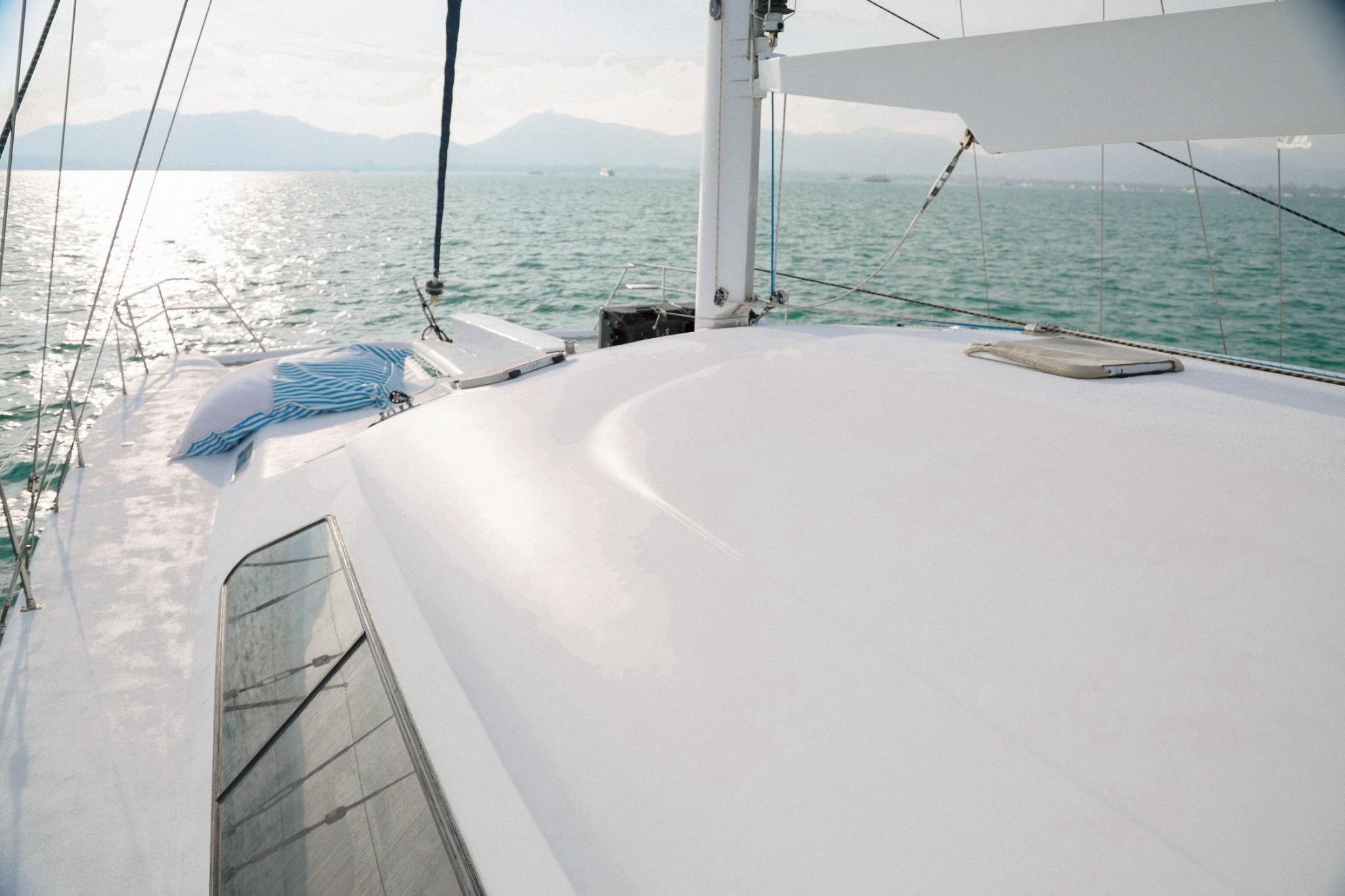 Sailing yacht IMP 55 (2001) on serene waters with distant mountains.