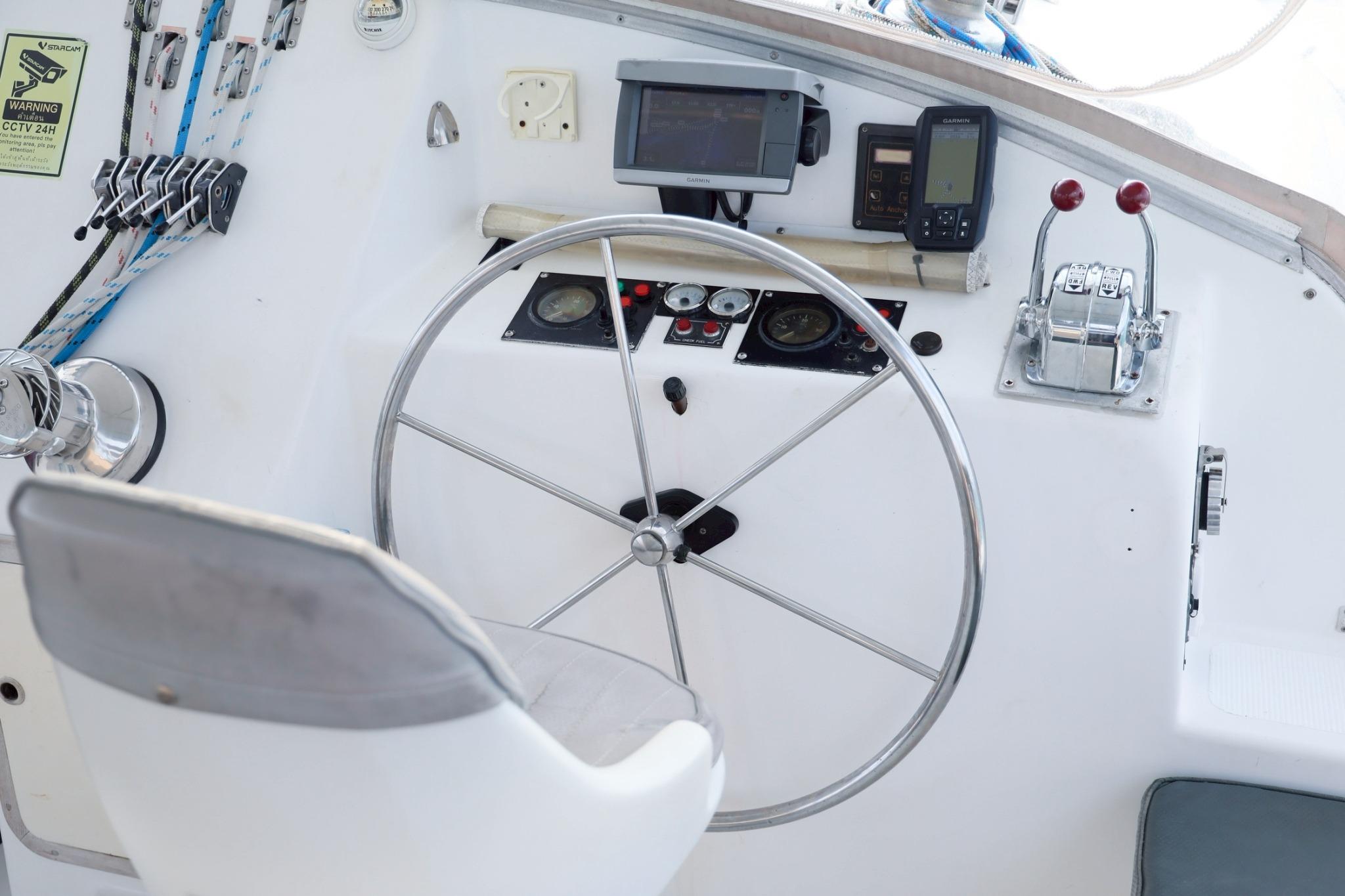 Boat steering wheel and control panel of IMP 55, 2001 model, with navigation equipment.
