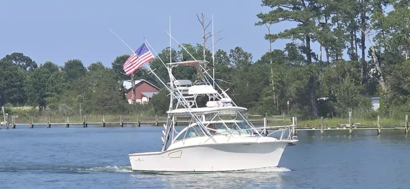  Yacht Photos Pics 2004 Albemarle 310 Express Fisherman boat cruising on a calm river with American flag.