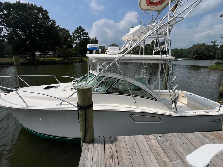  Yacht Photos Pics 2004 Albemarle 310 Express Fisherman boat docked by a scenic river.