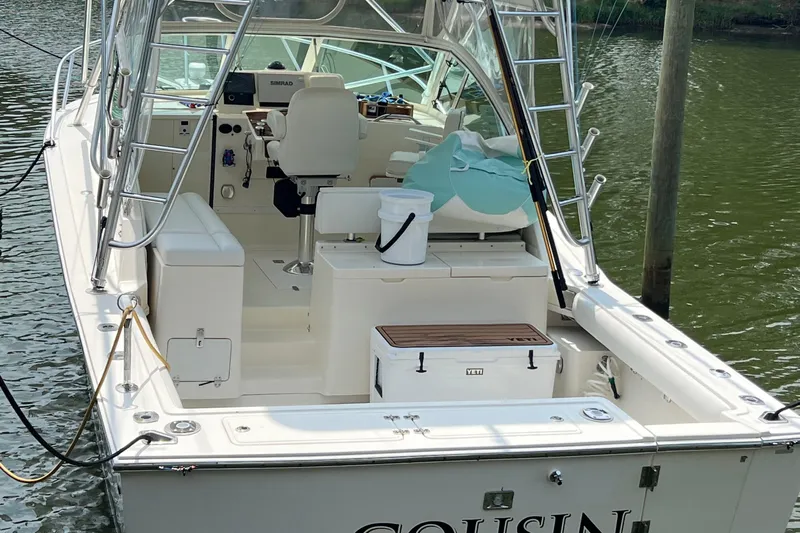  Yacht Photos Pics 2004 Albemarle 310 Express Fisherman boat docked, featuring fishing gear and seating.