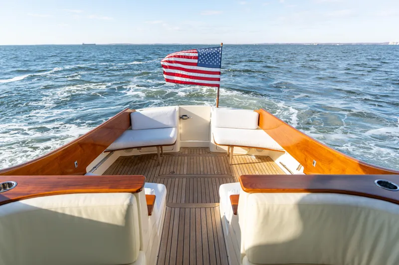 Upshort Yacht Photos Pics Hinckley Talaria 44 MKII Express 2010 yacht with American flag, cruising on open water.